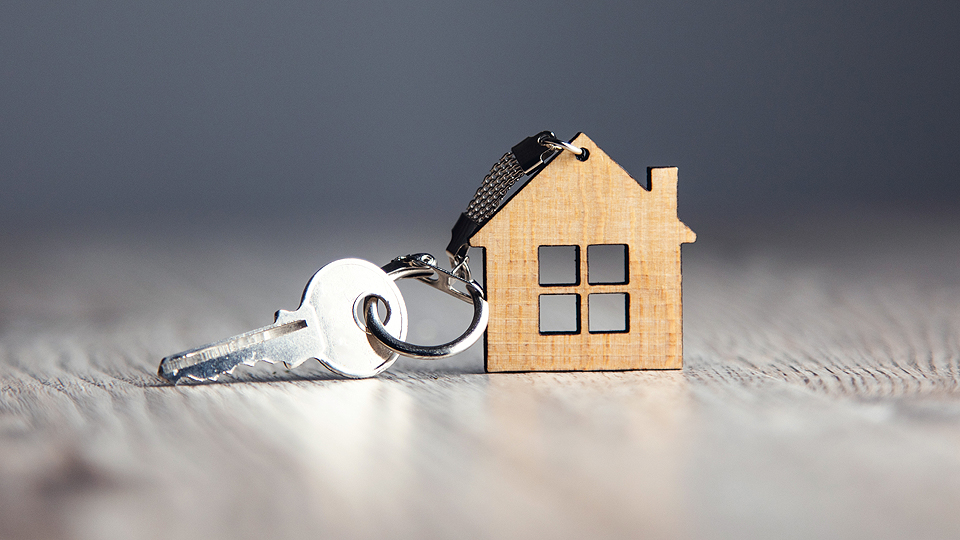 Bilden visar en nyckel med en nyckelknippa av ett hus