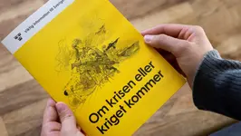 Någon håller broschyren om krisen eller kriget kommer i händerna